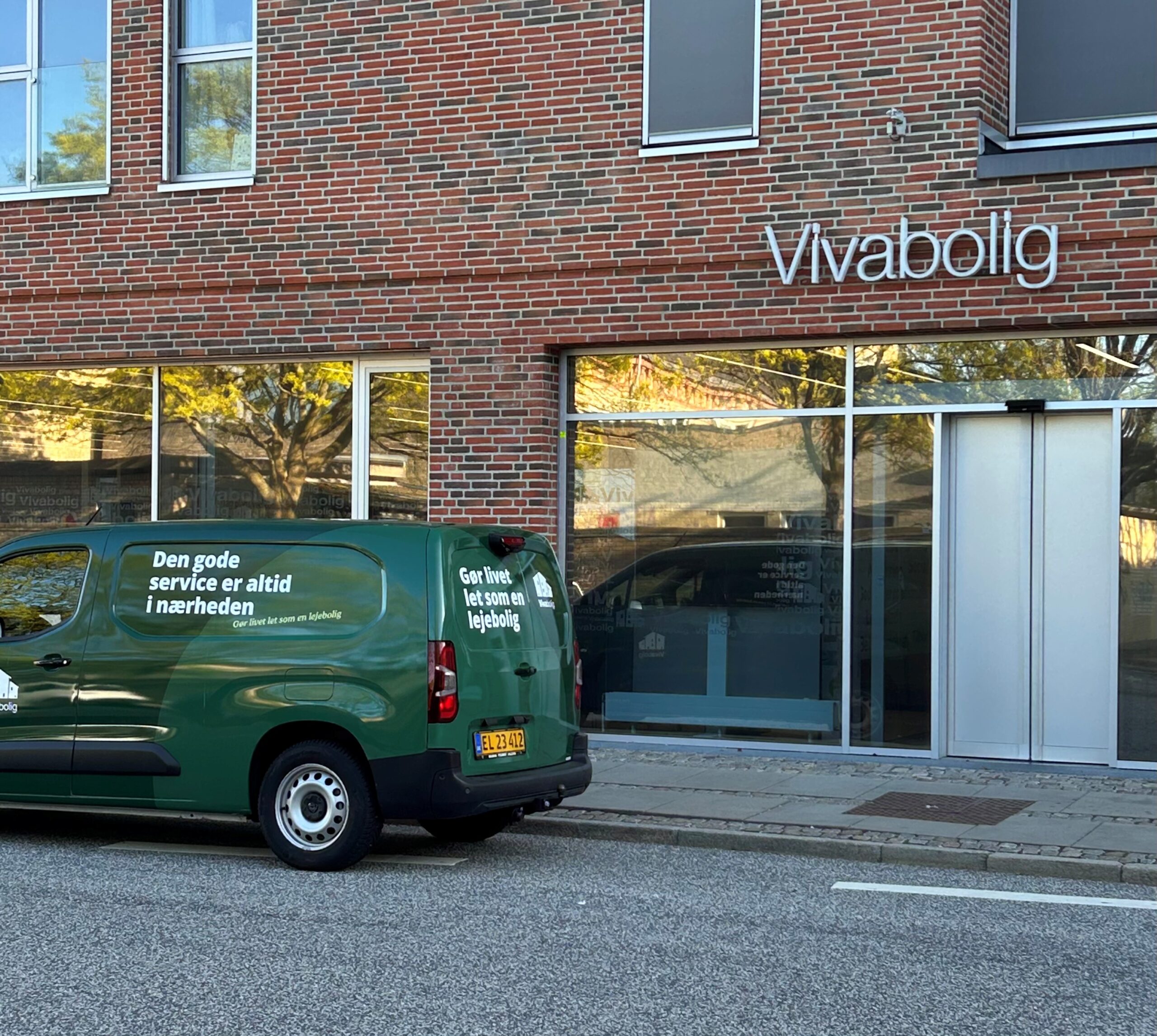Grøn servicebil parkeret foran Vivabolig i Aalborg – ventilationsservice og vedligehold